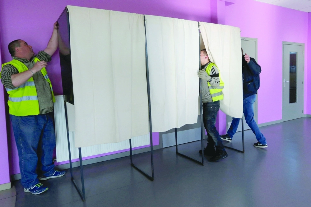 عمال يجهزون مقرا للاقتراع في شمال فرنسا أمس                                      (رويترز)