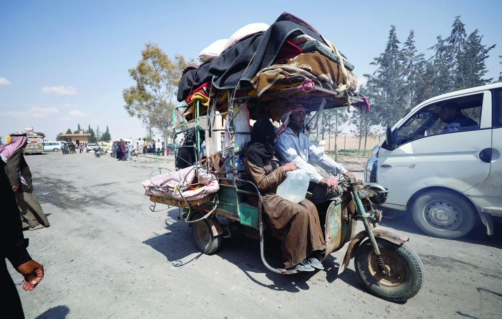 عائلة سورية هاربة من الرقة تحمل أغراضها على دراجة نارية                                        (رويترز)