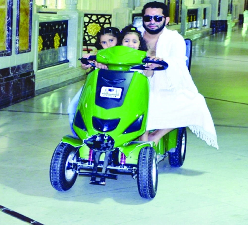 معتمر يقود عربة في المسعى برفقة أطفاله         (عبدالمحسن دومان)