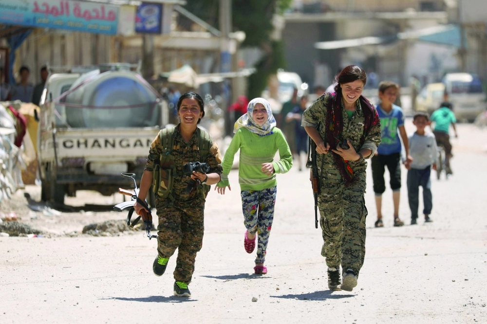 مقاتلات بقوات قسد في مدينة الطبقة بعد تحريرها من داعش                                (رويترز)