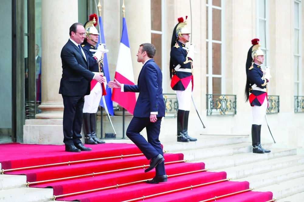 هولاند يصافح الرئيس الجديد على سلم قصر الإليزيه أمس (إ ب أ )