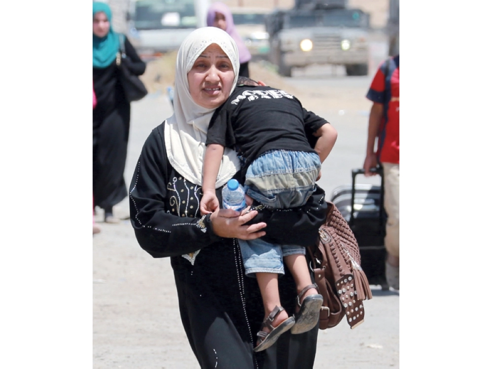 عراقية تحمل ابنها هاربة من القتال غرب الموصل (إ ب أ)