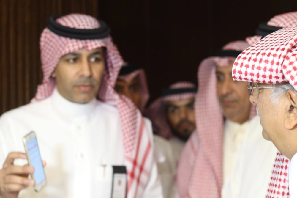 أحد الحضور يعرض على المعلمي معلومات على جواله (مكة)