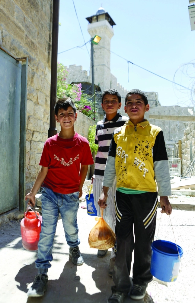 أطفال فلسطينيون يحملون طعاما في الخليل        (إ ب أ)