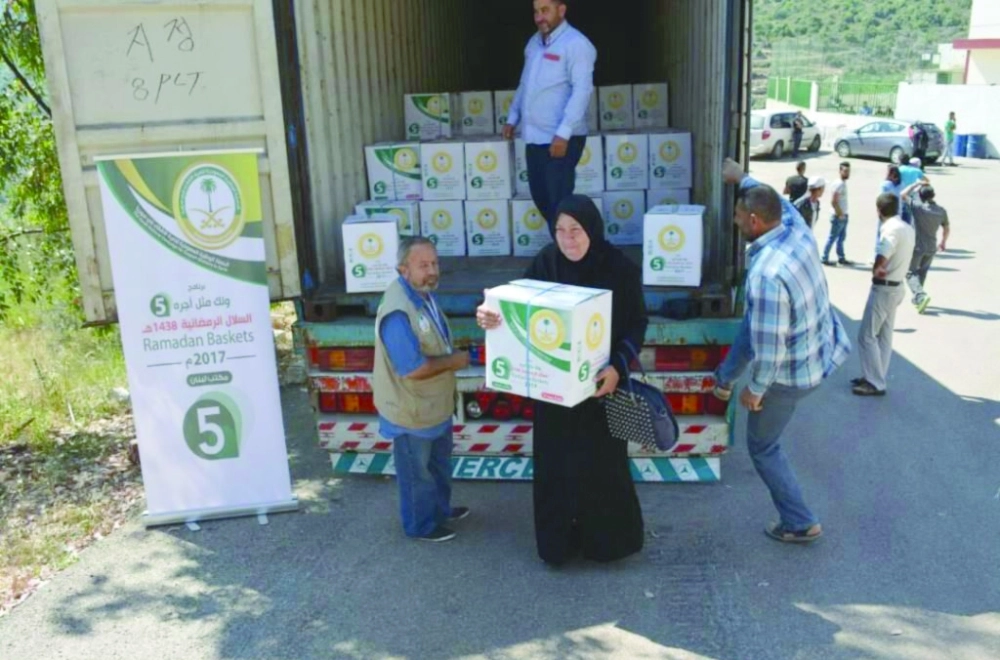 سوريون بطرابلس وشبعا يتسلمون سلالا رمضانية       (واس)