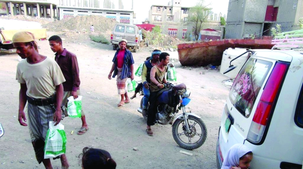 يمنيون في تعز يحملون وجبات رمضانية من مركز الملك سلمان (واس)