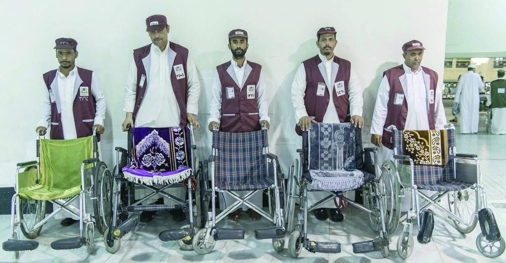 عدد من الشباب يعملون في مشروع دفع العربات بالمسجد الحرام             (واس)