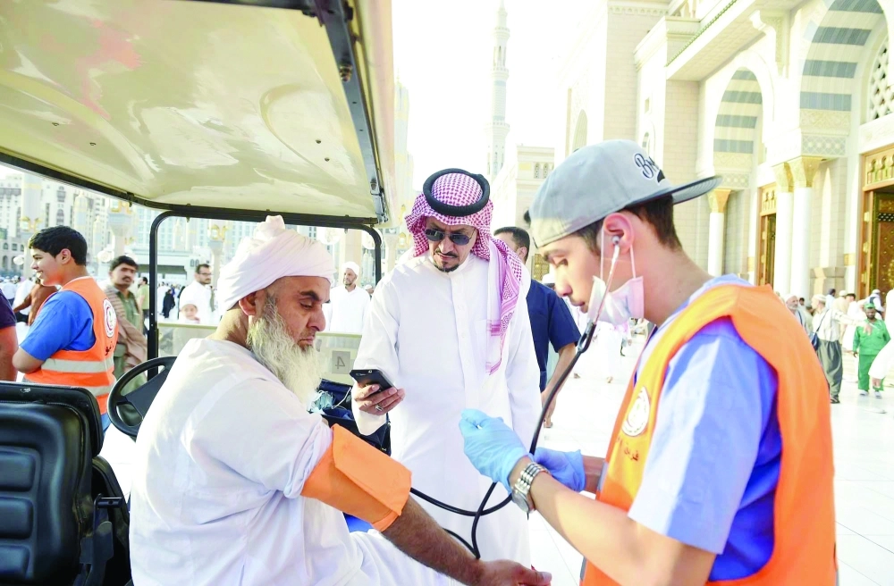 شاب يقدم الخدمة الإسعافية لأحد زوار المسجد النبوي 