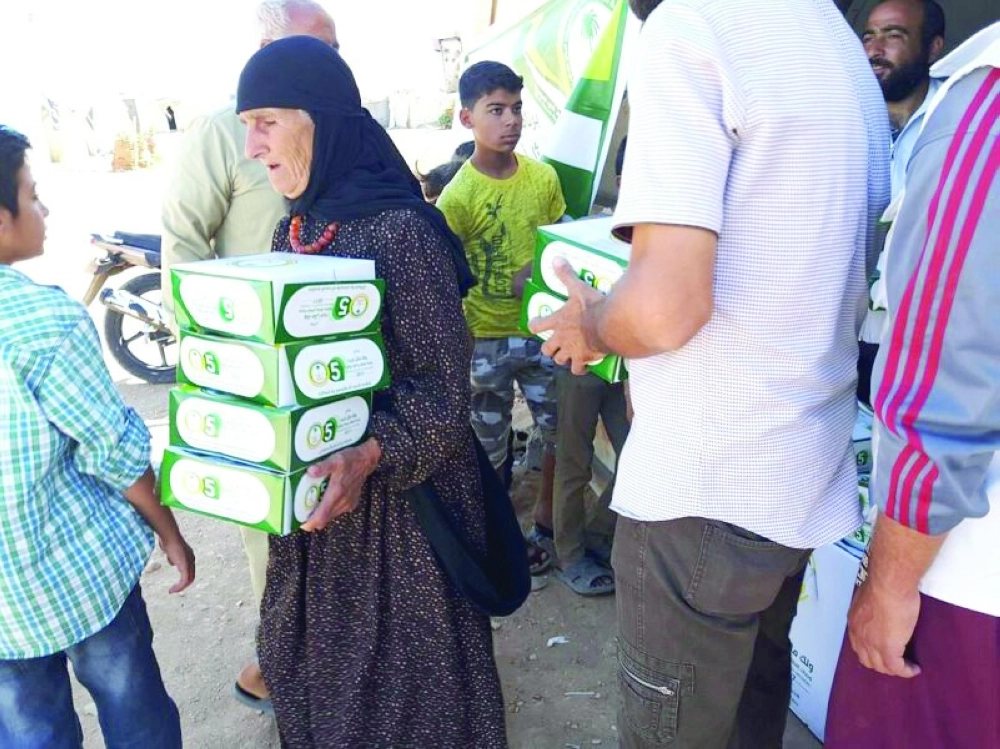 نازحون سوريون يتسلمون وجبات إفطار سعودية                                     (واس)