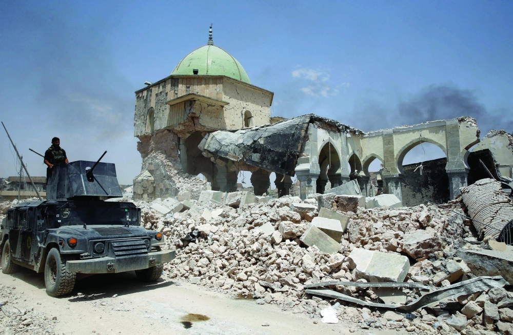 مدرعة تسير أمام بقايا جامع النوري الكبير          (رويترز)