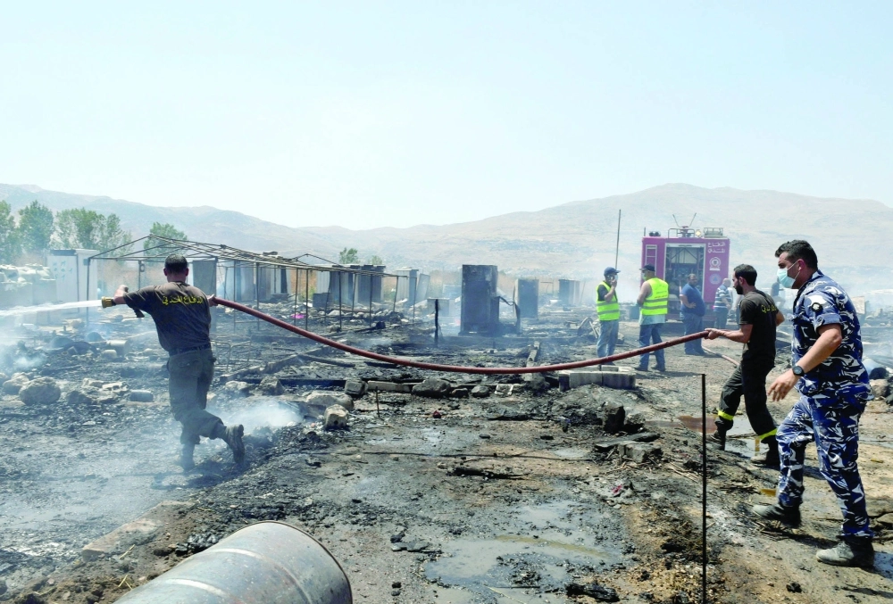 رجال الإطفاء ينظفون موقع التفجير في دمشق أمس (رويترز)