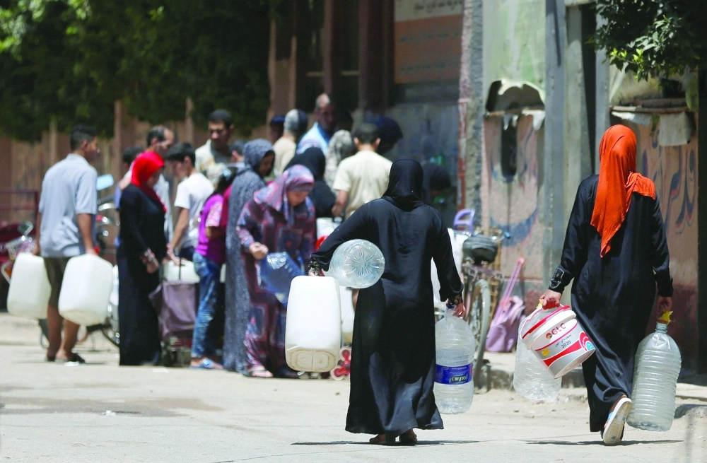 مصريون يملأون قوارير بالمياة الباردة من حر القاهرة (رويترز)