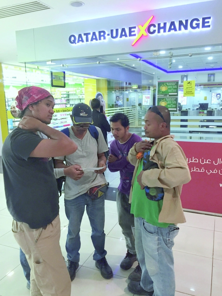 عمالة أمام أحد محال الصرافة بالدوحة               (مكة)