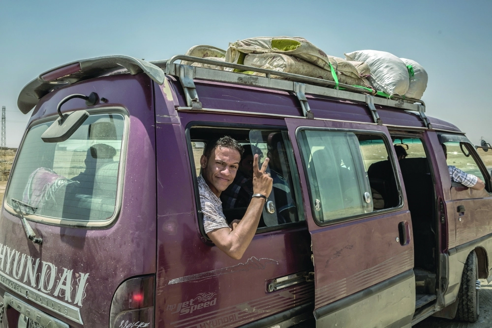 مدنيون في الموصل يلوحون بعلامات النصر خلال احتفالاتهم بدحر داعش            (د ب أ)