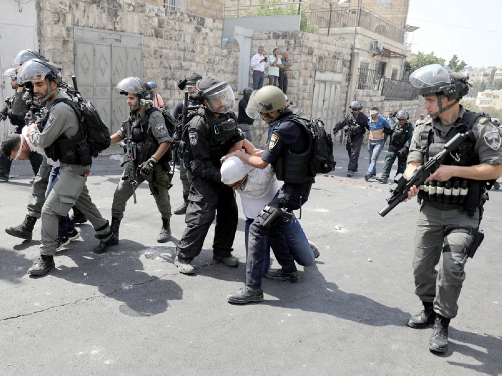 جنود الاحتلال يعتقلون فلسطينيين خارج القدس القديمة أمس (رويترز)