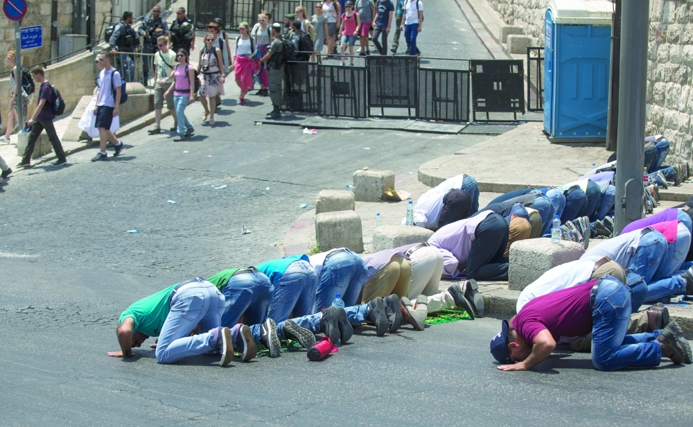 فلسطينيون يصلون خارج الأقصى رفضا لزرع أبواب الكترونية على مداخله                                                                                   (إ ب أ) 