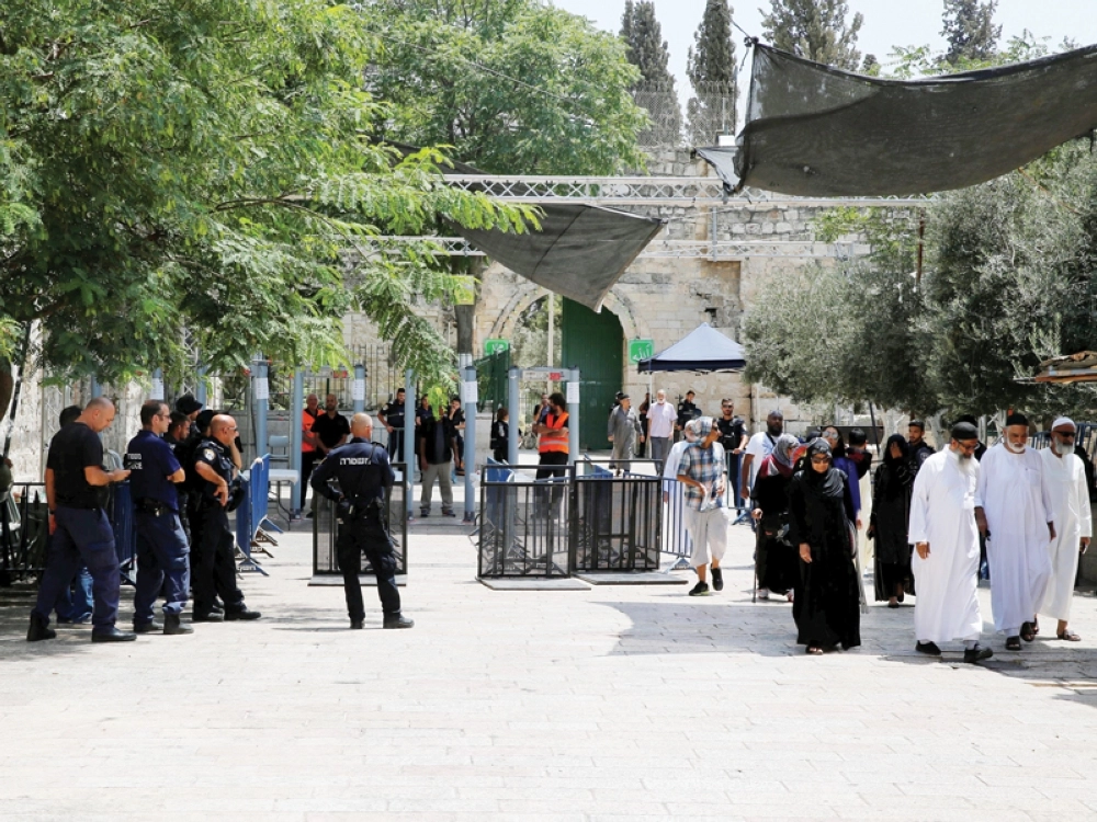 فلسطينيون يعبرون مدخل القدس القديمة عبر البوابات الالكترونية أمس (رويترز)