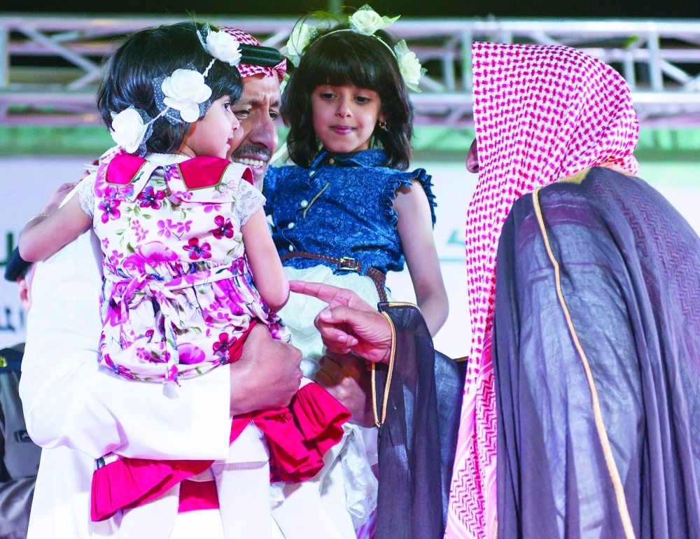  .. ويحتضن طفلتين خلال حفل التكريم