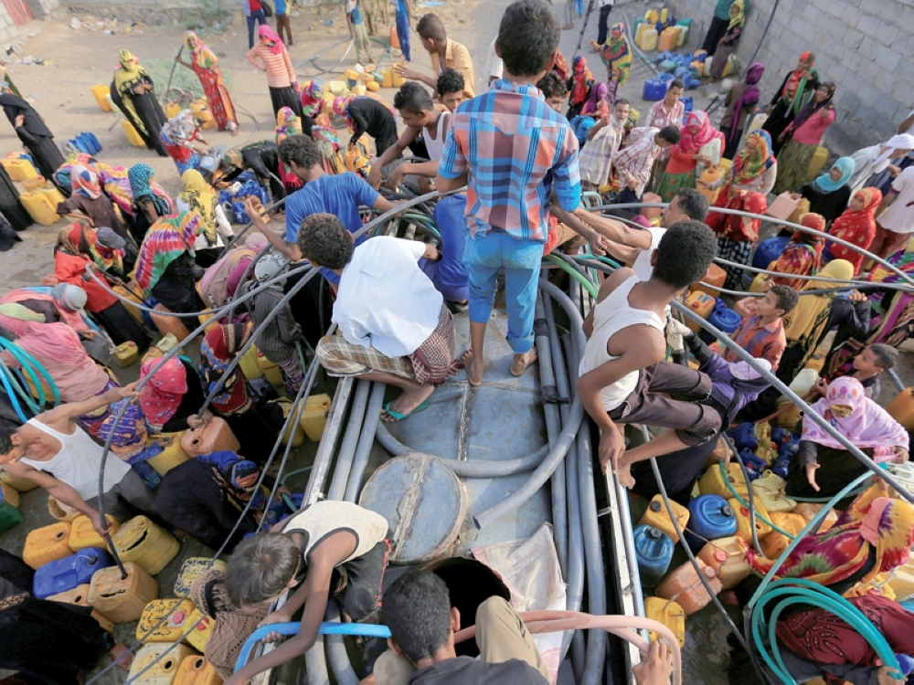 زحام يمنيين حول سهريج في الحديدة للحصول على الماء أمس (روتيرز)