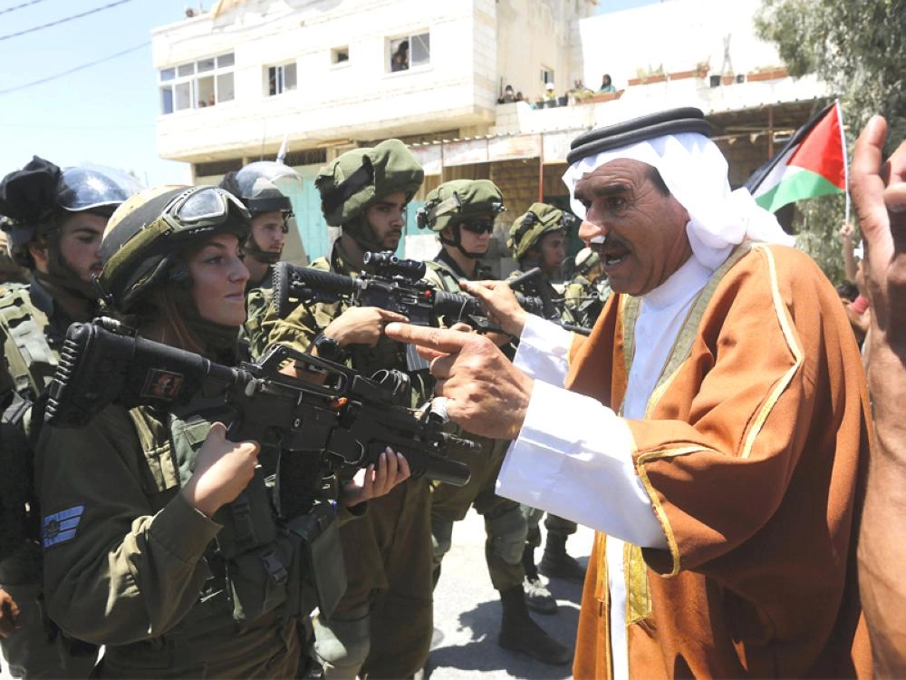 فلسطيني يجادل قوات الاحتلال بعد صلاة الجمعة في مدخل مدينة دورا جنوب الخليل ( إ ب أ )