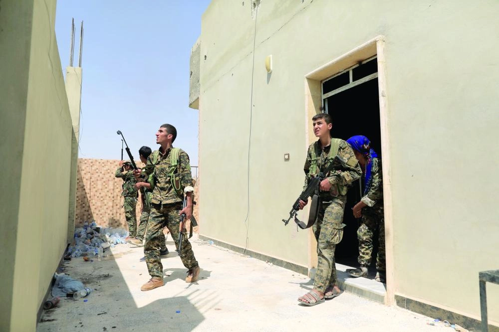 مقاتلون من قوات سوريا الديمقراطية خلال اشتباكات مع داعش بالرقة (رويترز)