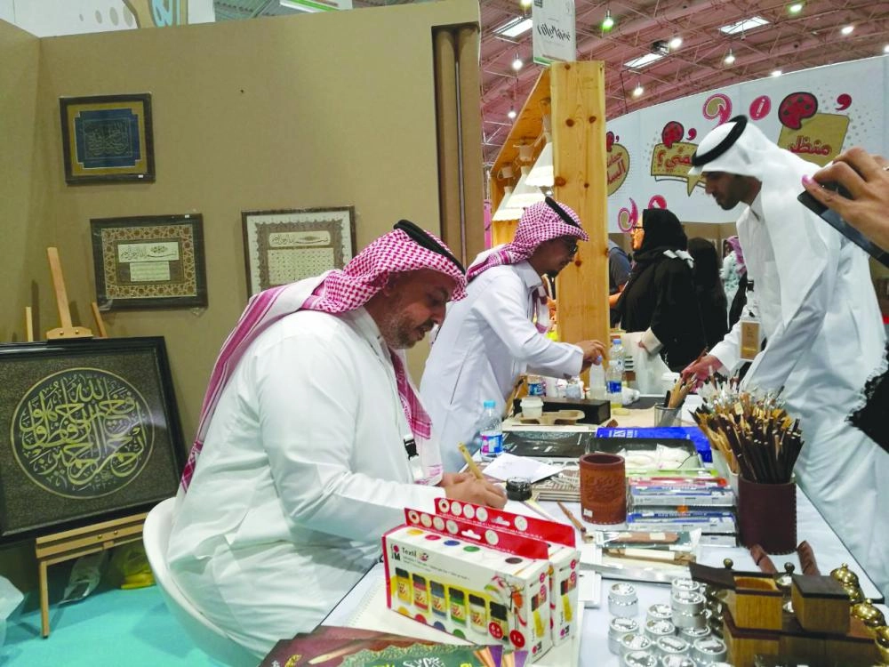 خطاطون أمام الزوار في الجناح (مكة)