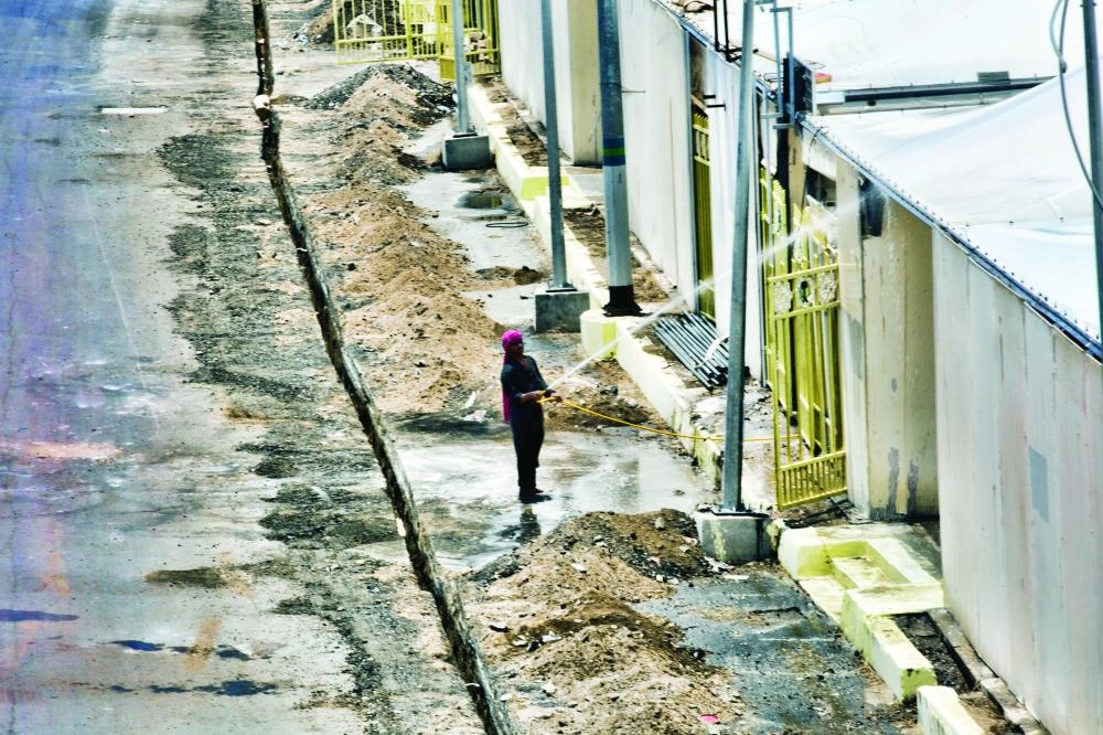 عامل يرش الماء لتنظيف الخيام 
(رصد وتصوير: أنس الحارثي)