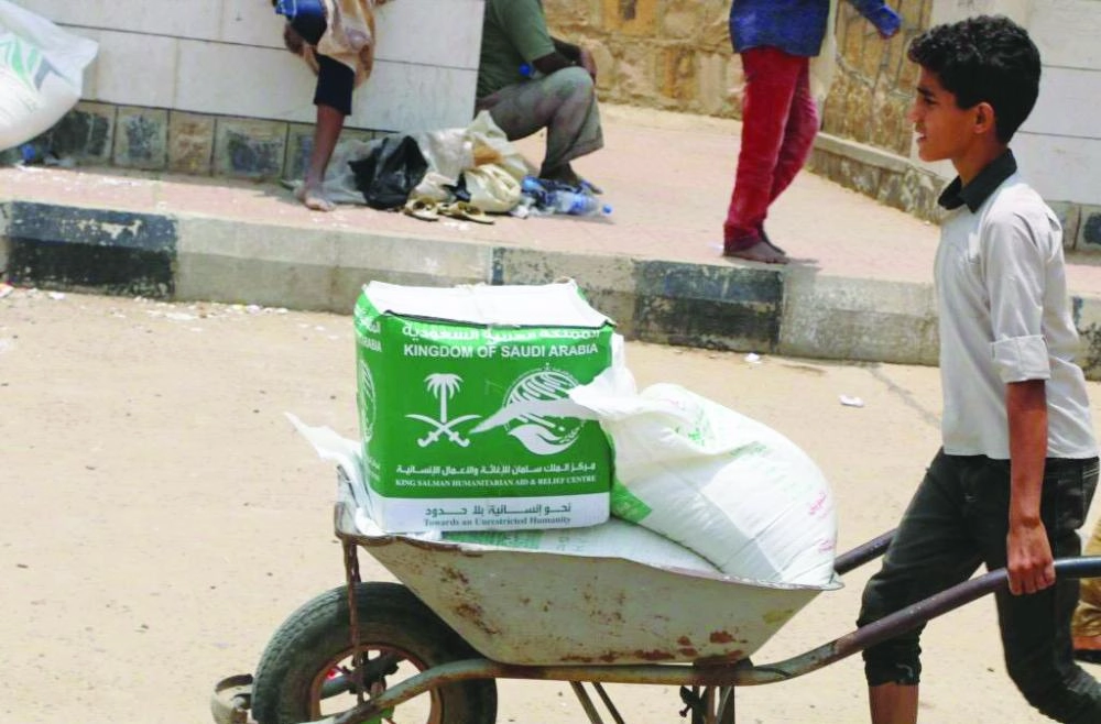 فتى يمني بتعز يدفع عربة محملة بالمساعدات السعودية (واس)