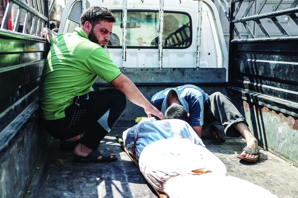 






سوريان بجوار جثمان رجل قتل بغارة للنظام في دوما                                                                                                         (إ ب أ)  