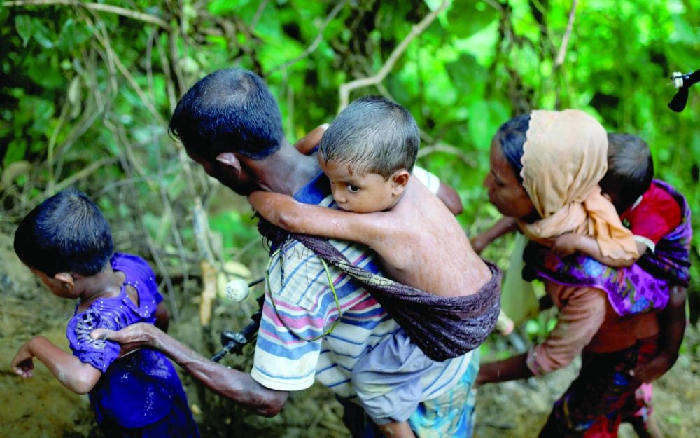






أسرة روهينجية تتسلق تلالا بعد عبورها حدود ميانمار إلى بنجلاديش   (رويترز)