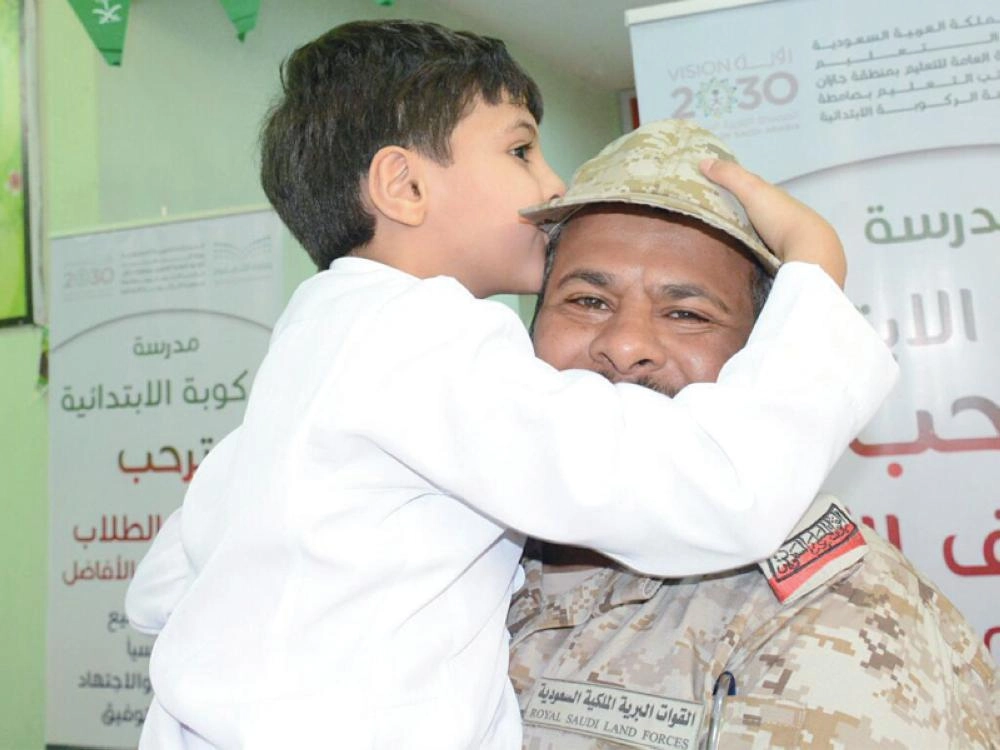 طفل يقبل رأس أحد الضباط بالحد الجنوبي أمس (واس)