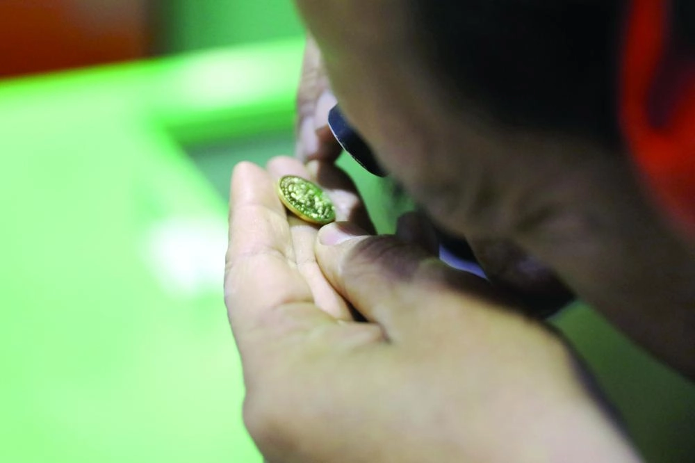 An employee checks out a coin at the La case de Nacional de la Moneda (National Mint House) in downtown Lima, Peru, Seotemder 20, 2017. REUTERS/Guadalupe Pardo