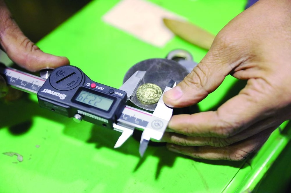 An employee checks out a 10 cent of Sol coin at the La Casa de Nacional de la Moneda (National Mint House) in downtown Lima, Peru, September 20, 2017. REUTERS/Guadalupe Pardo