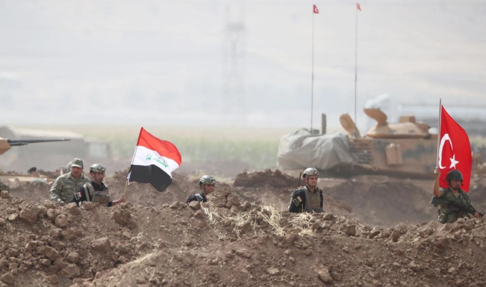 جنود عراقيون وأتراك يحملون علمي البلدين في مناورات عسكرية مشتركة في منطقة سلوبي الحدودية                                                       (رويترز)