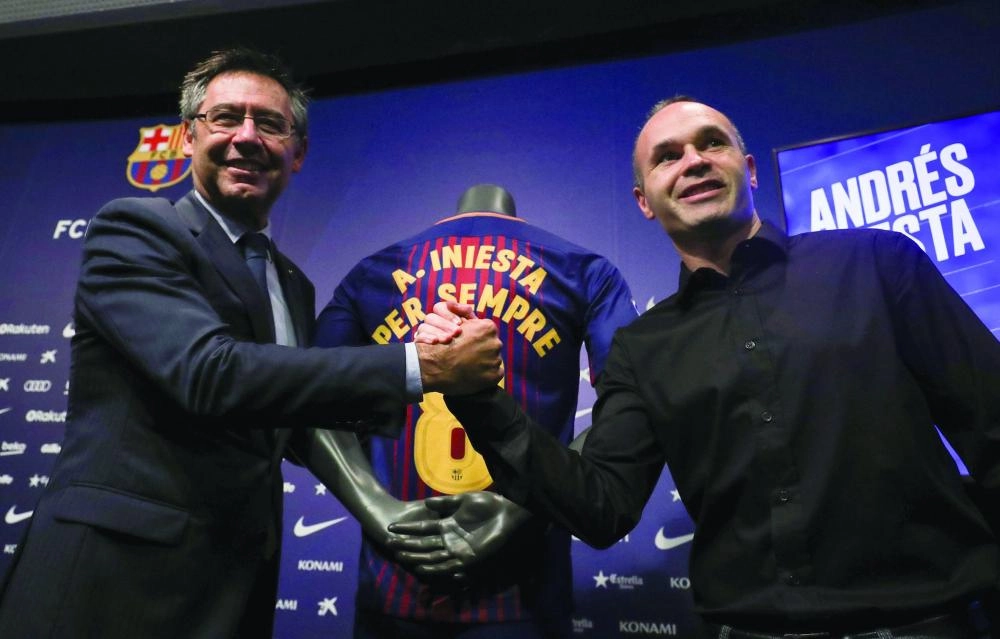 






إنييستا بجانب رئيس برشلونة عقب تجديد العقد (رويترز)