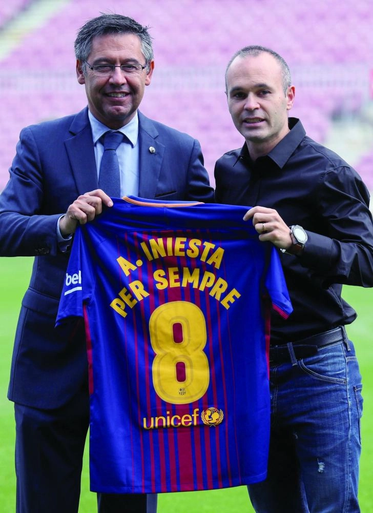  إنييستا بجانب رئيس برشلونة عقب تجديد العقد أمس (رويترز)