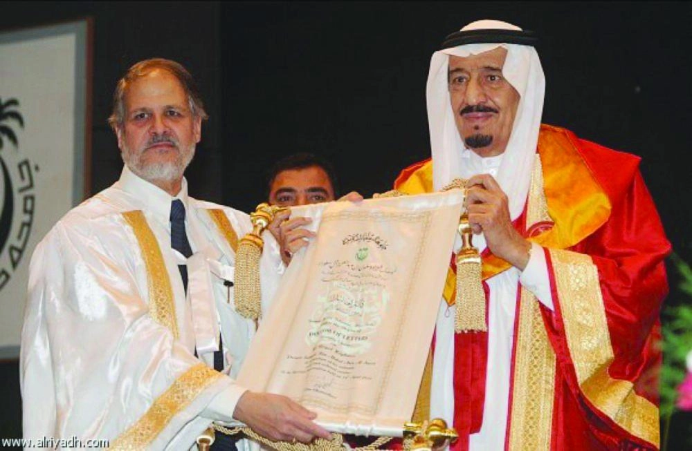 خلال تسلمه شهادة الدكتوراه وإلى جانبه رئيس الجامعة الملية عام 2010