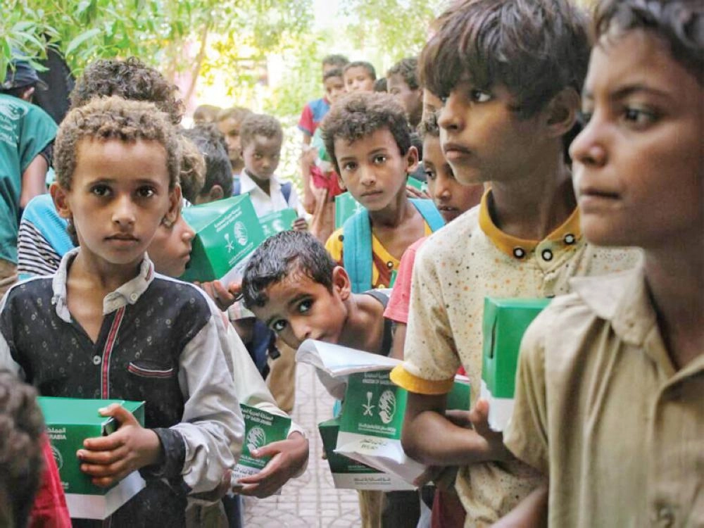 أطفال يمنيون نازحون بالمخا يتسلمون وجبات غذائية من مركز الملك سلمان (واس)
