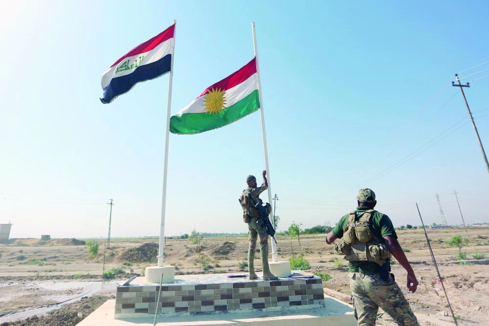 






جندي عراقي ينزل العلم الكردستاني من كركوك ويبقي علم العراق                   (رويترز)