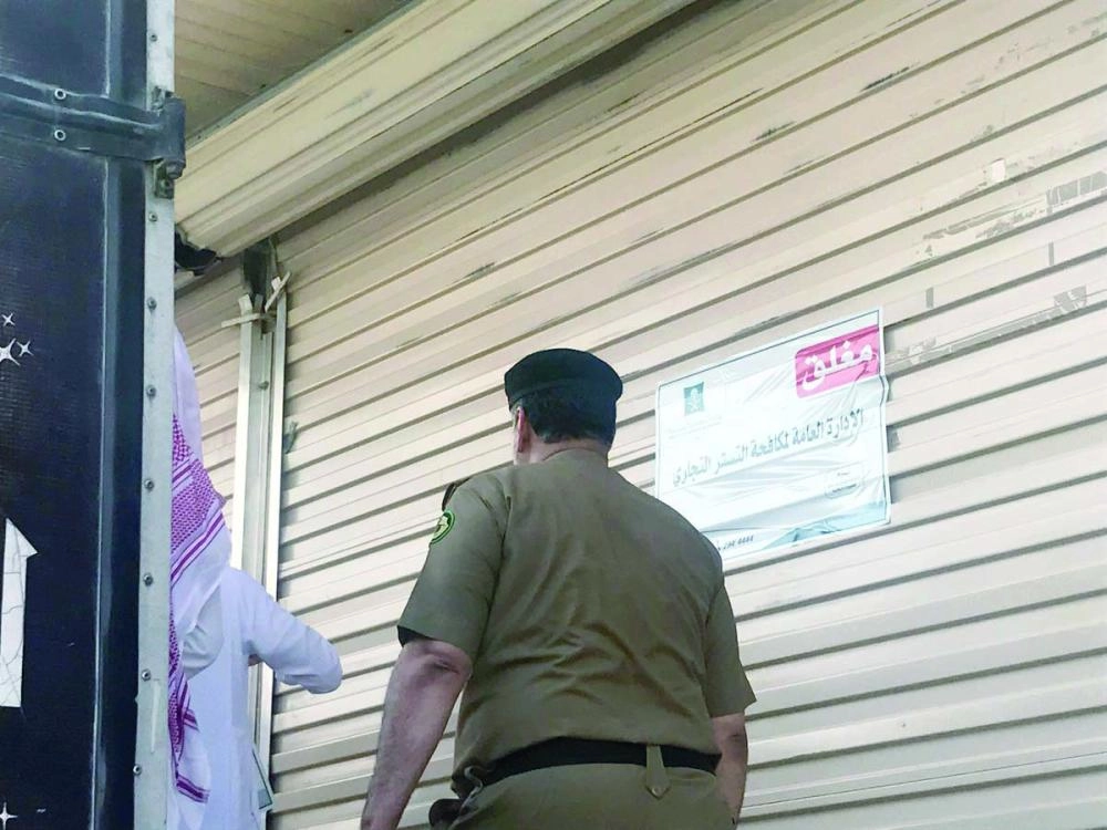 أثناء إغلاق محل يعمل بالتستر التجاري (وزارة التجارة)