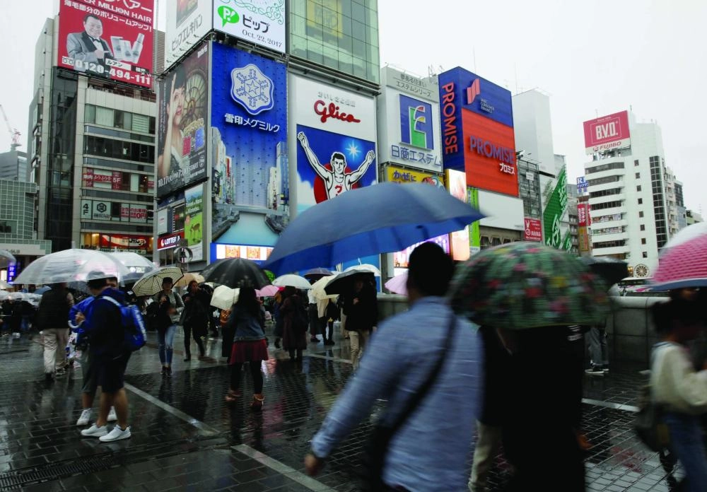 






متسوقون تحت المظلات مع اقتراب إعصار لان من البر الرئيسي لليابان            (رويترز)