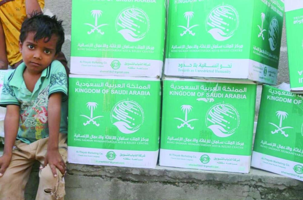 طفل بجوار مساعدات غذائية من مركز الملك سلمان