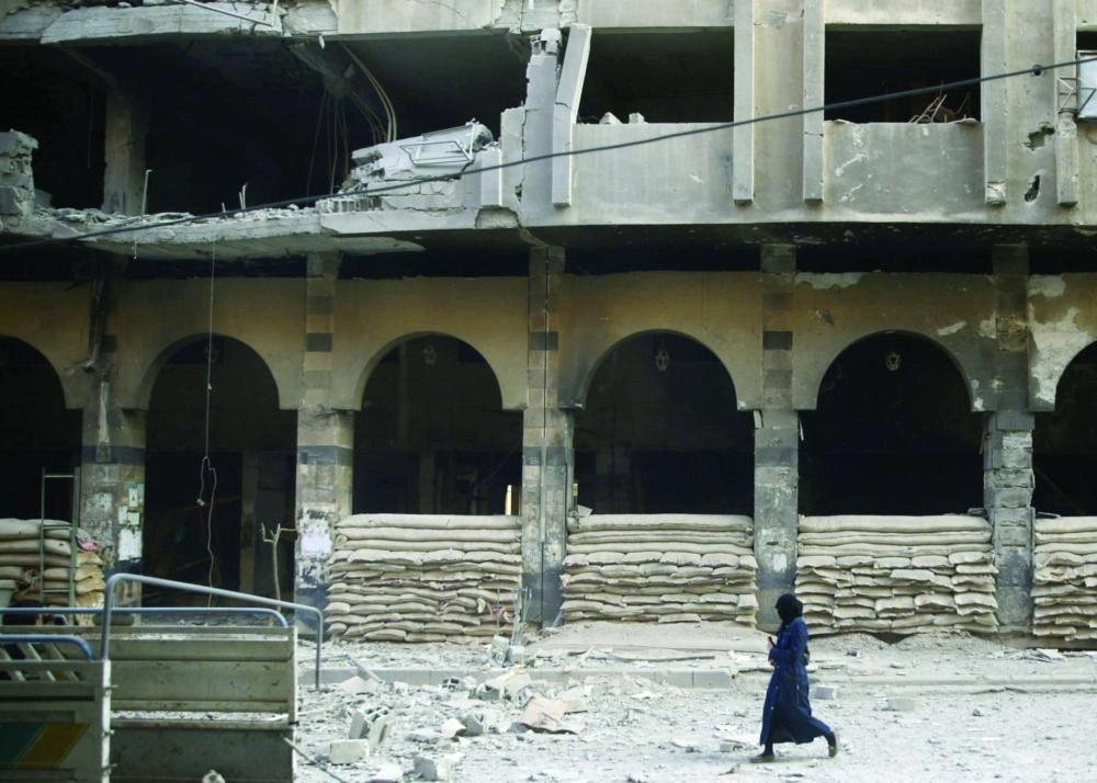 A woman walks at a damaged site after an airstrike in the rebel-held city of Douma, in the eastern Damascus suburb of Ghouta Syria November 2, 2017. REUTERS/Bassam Khabieh