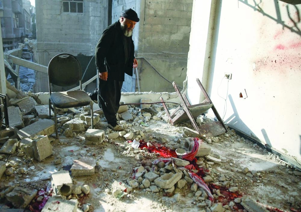 






مواطن سوري يقف على آثار الدمار في بلدة الدومة                                      (رويترز)
