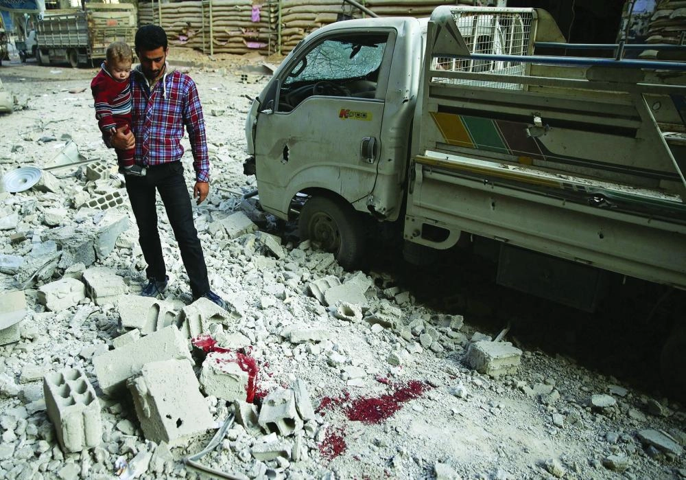 ATTENTION EDITORS - VISUAL COVERAGE OF SCENES OF INJURY OR DEATH A man holds a child as he stands on the rubble of damaged buildings after an airstrike on the rebel-held city of Douma, in the eastern Damascus suburb of Ghouta Syria November 2, 2017. REUTERS/Bassam Khabieh