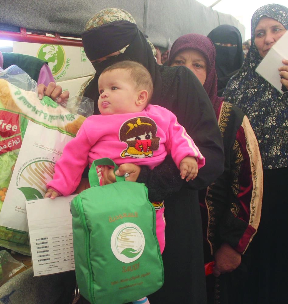 سوريون يتسلمون من مركز الملك سلمان المستلزمات الشتوية (واس)