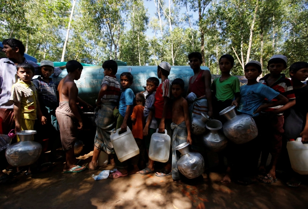 أطفال الروهينجا في طابور للحصول على مياه للشرب في معسكر للاجئين ببنجلاديش (رويترز)