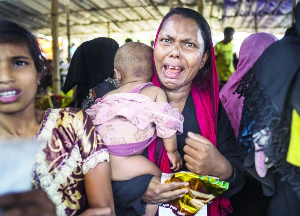 






روهينجية تحمل طفلتها، تبكي في طابور للحصول على الطعام بمعسكر للاجئين في بنجلاديش                      (د ب أ)
