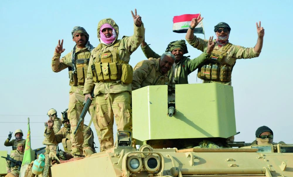 






أفراد من القوات العراقية يرفعون إشارات النصر عقب تطهير راوة                    (رويترز)
