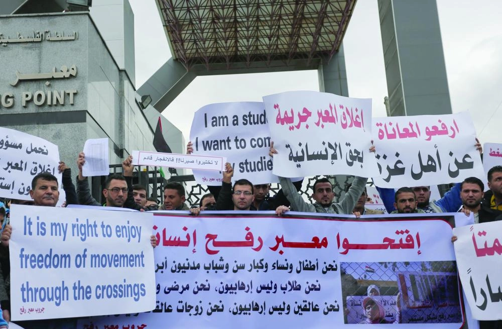 Palestinian students hold banners and placards during a protest held to demand travel to complete their study abroad, at the Rafah Border Crossing in Rafah, Gaza Strip, the Palestinian Territories, 23 November 2017. Photo: Ashraf Amra/APA Images via ZUMA Wire/dpa